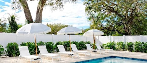 Six white lounge chairs & stripped bohemian umbrellas