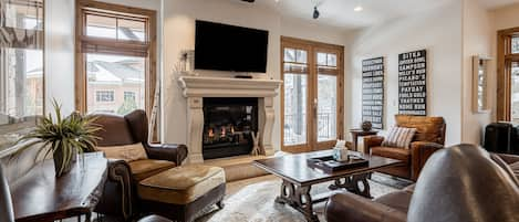 Living Room with plush leather sleeper sofa, Smart TV, and a cozy gas fireplace