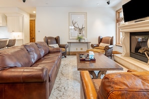 Living Room with plush leather sleeper sofa, Smart TV, and a cozy gas fireplace