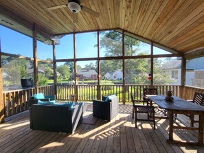 Beautiful and relaxing large screened porch with dining table and seating area.
