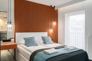 Cozy bedroom with a comfortable bed, soft blue accents, and wooden wall panels adding a warm touch.

