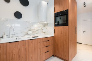 Fully equipped kitchen with marble countertops, wooden cabinetry, and state-of-the-art appliances.

