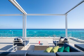 Lounge area on the ocean balcony. The balcony is equipped with a retractable awning for shade. 