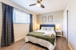 Queen-sized bedroom complete with 2 nightstands, lamps, and a ceiling fan to ensure a comfortable sleep. 