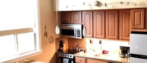 Kitchen fully equipped with dishwasher, oven, stove top, microwave, coffee maker