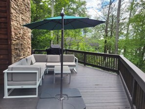 Deck Lounge: Spacious seating area shaded by an umbrella, perfect for sunset chats and nature views!

