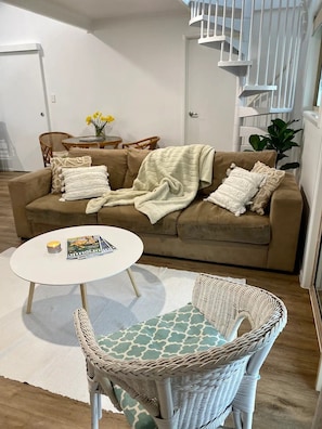 Lounge area showing spiral stairs in background leading up to the loft bedroom.