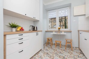 Fully equipped kitchen with white cabinets, ample counter space, and a charming patterned floor.

