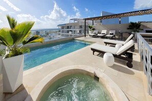 A jetted spa tub for extra relaxation with a pool & sea view