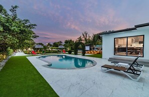 Heated pool and loungers next to the dining area.