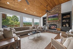 From the entryway, you step into a spacious living room with huge windows, phenomenal views of Mt. LeConte, and a large gathering place for all your friends and family