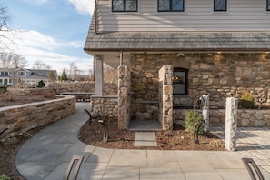 Pathway past EV charger + outdoor shower to back patio with full outdoor kitchen