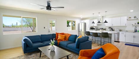 Living room with modern kitchen in background. 