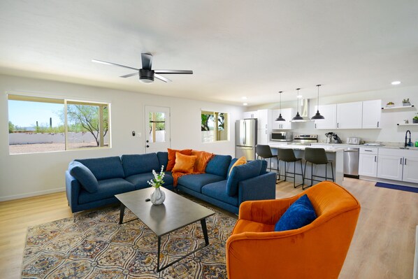 Living room with modern kitchen in background. 