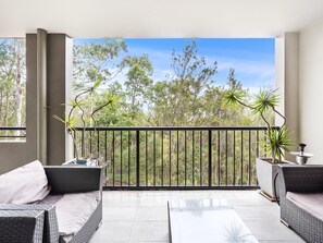 Main large balcony with outdoor furniture, hinterland and lush native tree views