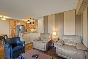 Create a cozy retreat in your living area featuring three comfortable chairs, a Smart TV, an indoor gas fireplace, a door to an outside deck, and a window AC unit.