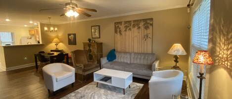 Living room with futon sofa, smart tv, and PS3.