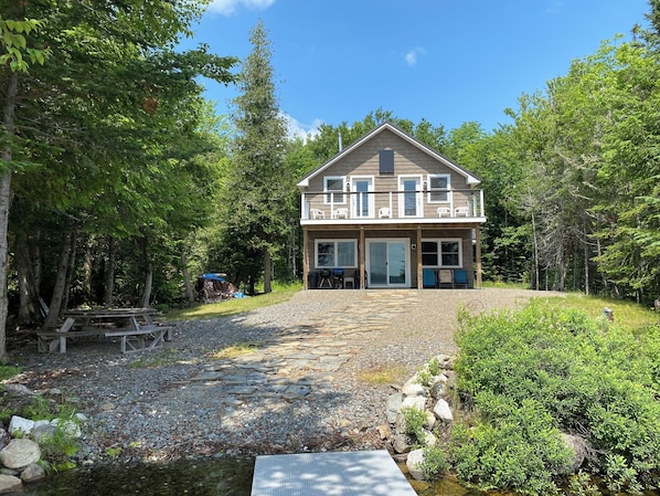 Lake house, front yard and stone path to lake, balcony and patio