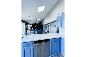 View from kitchen- open floor plan including dining & living room w 70” tv