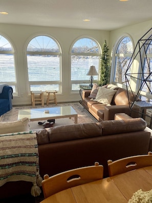 Living room on main floor with leather couches surrounded waterfront views