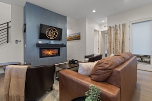 The main level living room has a comfortable leather sofa and a gas fireplace.