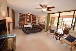 Open concept kitchen-dining-living room with large doors out to the lanai.