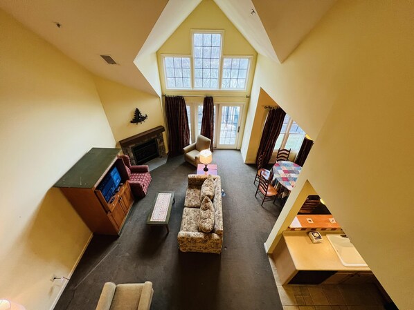 Large den area with a new LCD smart Roku TV, fireplace and lake views