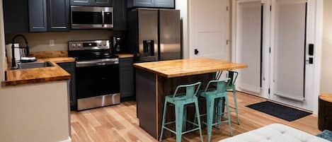 Stainless steel appliances in fully stocked kitchen.