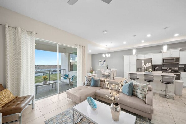 Modern open concept of living room, dining room and kitchen with island!LAKE VIEW & 55" Smart TV!#Disney #Parks #kingdom #springs #StoreyLake #Apartment #Vacation #Rental #waterpark #Kissimmee #Orlando #universal #citywalk