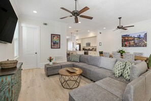 Living room to the rear of home open to kitchen and dining areas