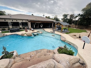 Huge water fall, jumping rocks a table to enjoy snacks while seating in the pool