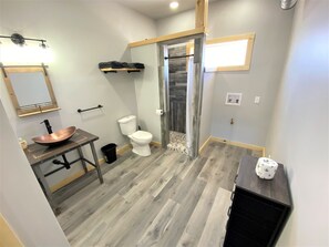 Spacious bathroom with custom vanity, sink and shower.