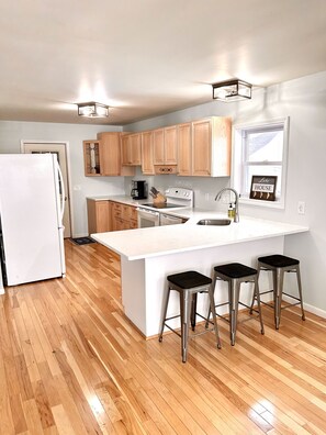 Kitchen and stools. There is a plug in for by the far right stool for usb, usb-c