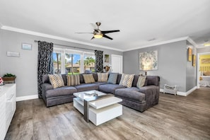 The perfect family room to read, play and enjoy. The living room is open and spacious. Enjoy the 55" TV with cable and smart apps. The room is perfectly located with easy access to all spaces in the home. The large windows bring in ample lighting.