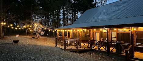 Back yard area with firepit, bag toss, string lights