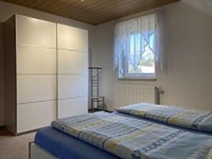 Schlafzimmer 1 mit Kleiderschrank und Fenster