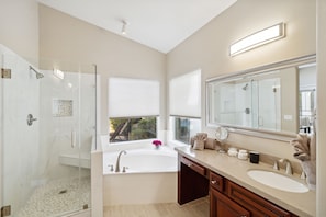 primary bathroom attached to bedroom. Soaking tub and separate shower. Pool view
