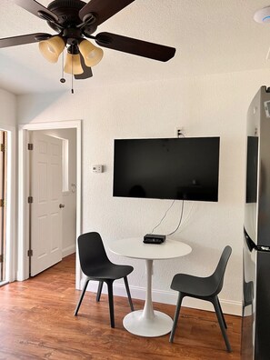 Dining table with 2 chairs and Smart TV.