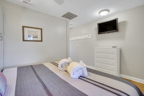 King-sized bed as guests enter the condo and smart TV.