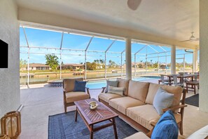 The outdoor living room invites relaxation and includes a wall mounted Roku TV.