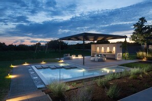 Ein überdachter Pavillon mit Lounge-Sofas und ein kleiner beleuchteter Designer-Swimmingpool im Innenhof der Kroatien luxuriösen Villa Art Zen in der Stadt Bale in Istrien