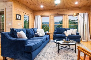 Living room that comfortably seats 6. 65" Roku TV, and gas fireplace.