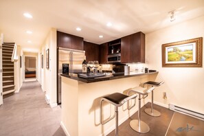 Renovated kitchen has plenty of room for three people to eat at the bar area.