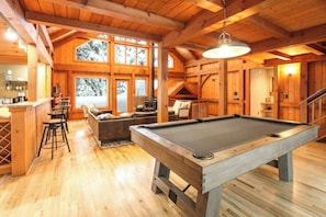 Living Room with pool table and a cozy wood burning fireplace.