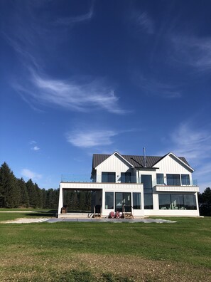 West side of house. Floor to ceiling windows and extensive outdoor living space