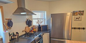 Features a full gas range, stone countertops, and a spacious island for cooking and gathering.