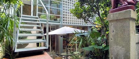 Facade to the garden, terrace and koi pond under the access stairs 