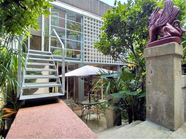 Facade to the garden, terrace and koi pond under the access stairs 
