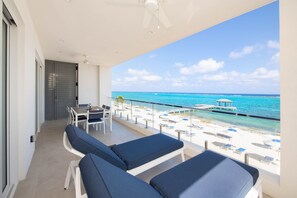 Private balcony furnished with sun loungers and an al fresco dining table. 