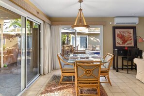 Dining table inside and table/chair seating out by the pool